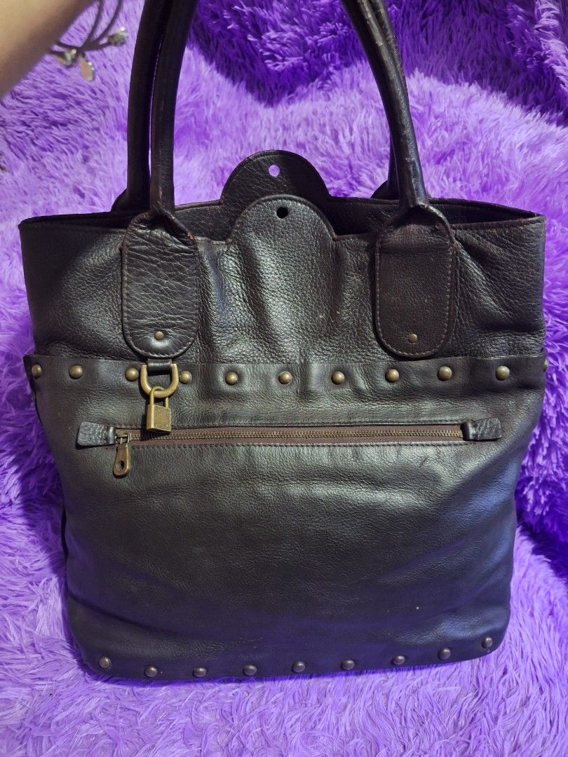 Chloé Dark Brown Leather Studded Handbag (Category: Luxury Bags & Wallets) located in Quezon City. Submitted by cloudymay (Listing ID 1469932122, Image 1). Description: - Brand: Chloé - Material: Dark brown pebbled leather with debossed logo - Accents: Bronze-tone vertical metal studs and exterior zippered pocket with padlock hardware - Straps: Dual top handles with minor wear and cracking on the leather coating - Condition: Pre-loved, well-maint