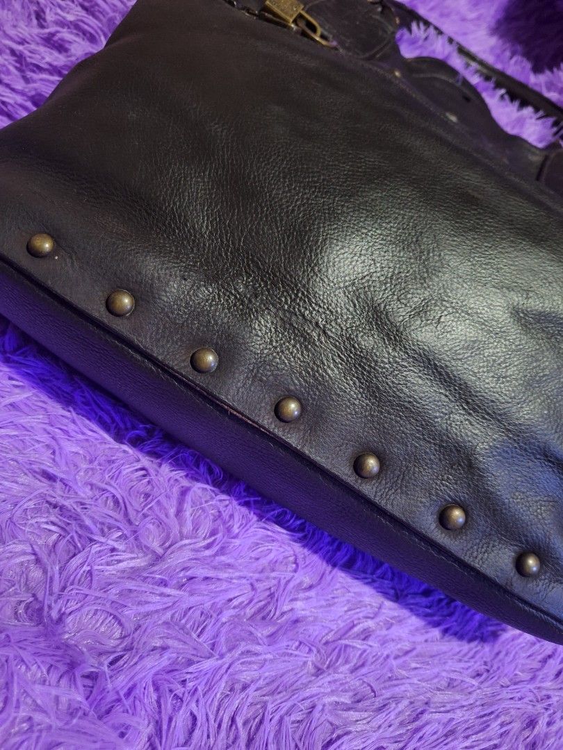 Chloé Dark Brown Leather Studded Handbag (Category: Luxury Bags & Wallets) located in Quezon City. Submitted by cloudymay (Listing ID 1469932122, Image 3). Description: - Brand: Chloé - Material: Dark brown pebbled leather with debossed logo - Accents: Bronze-tone vertical metal studs and exterior zippered pocket with padlock hardware - Straps: Dual top handles with minor wear and cracking on the leather coating - Condition: Pre-loved, well-maint
