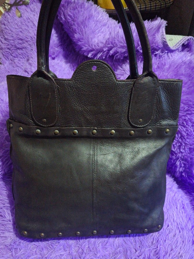Chloé Dark Brown Leather Studded Handbag (Category: Luxury Bags & Wallets) located in Quezon City. Submitted by cloudymay (Listing ID 1469932122, Image 2). Description: - Brand: Chloé - Material: Dark brown pebbled leather with debossed logo - Accents: Bronze-tone vertical metal studs and exterior zippered pocket with padlock hardware - Straps: Dual top handles with minor wear and cracking on the leather coating - Condition: Pre-loved, well-maint
