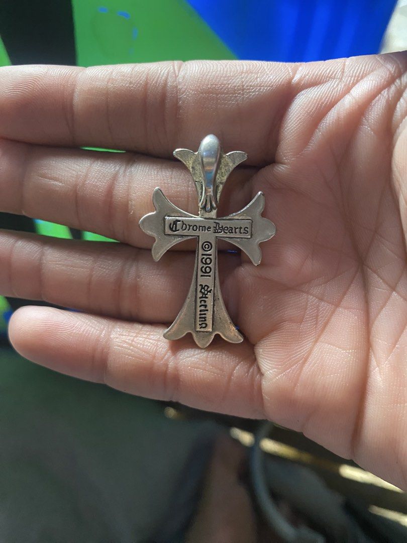 Chrome Hearts 1991 Sterling Cross Pendant (Category: Necklaces) located in Manila. Submitted by genggeng316 (Listing ID 1469945207, Image 2). Description: - Material: Solid 925 sterling silver with a nice dark patina in recessed areas - Design: Classic gothic lettering on the horizontal bar - Details: Stamped 1991 on the back, includes top loop for chains - Style: Solid weight, great standalone or for layering with other silver jewelry - Conditio