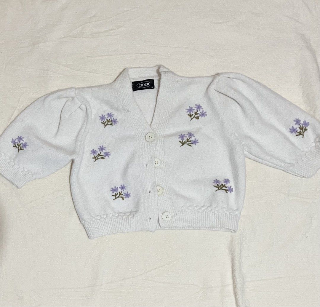 cider cropped knitting blazer (Category: Coats, Jackets and Outerwear) located in Manila. Submitted by yours_eventually (Listing ID 1469907275, Image 2). Description: - Brand/Style: Cider white cropped cardigan - Size: Medium - Details: Soft knit fabric with scattered embroidered purple flowers - Features: Puffed shoulders, long sleeves, V-neck, 4-button closure - Fit: Ribbed hem and cuffs for a great shape - Condition: Great layering piece for c