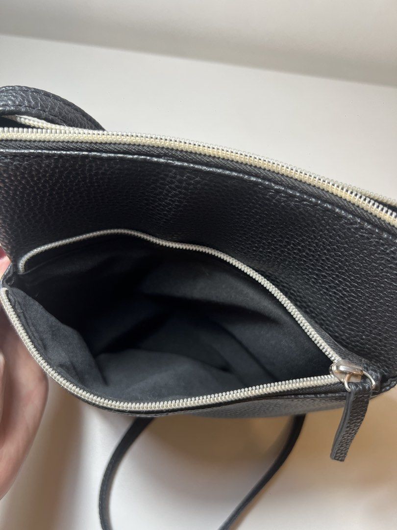 Clarks black leather sling bag (Category: Cross-body Bags) located in Mandaluyong City. Submitted by bbcage (Listing ID 1469878917, Image 3). Description: - Color: Black - Material: 100% durable polyvinyl chloride (pebbled faux leather) - Compartments: Secure main zip closure with fabric lining and handy front zippered pocket - Strap: Long and fully adjustable for a custom fit - Details: Cute hanging tassel charm with metallic studs - Style: Vers