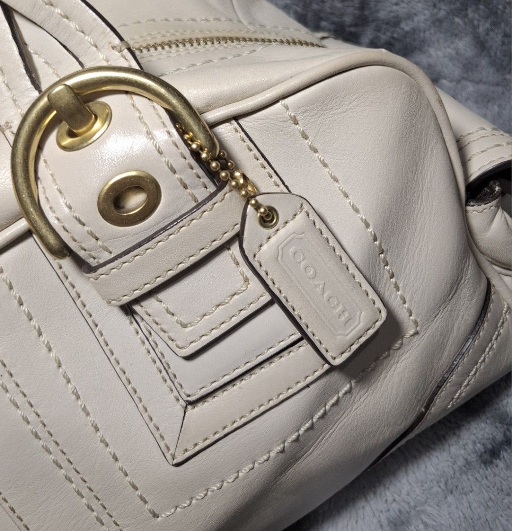 Coach Beige Leather Handbag with Braided Handles (Category: Luxury Bags & Wallets) located in Sorsogon. Submitted by johnmichae69459 (Listing ID 1469851961, Image 3). Description: - Y2k Coach mia soho bag - Genuine cream leather exterior with classic brass hardware - Comfortable braided shoulder handles and secure zip-top closure - Practical external buckle pockets on the sides and front - Includes matching Coach leather hangtag - Clean, versatil