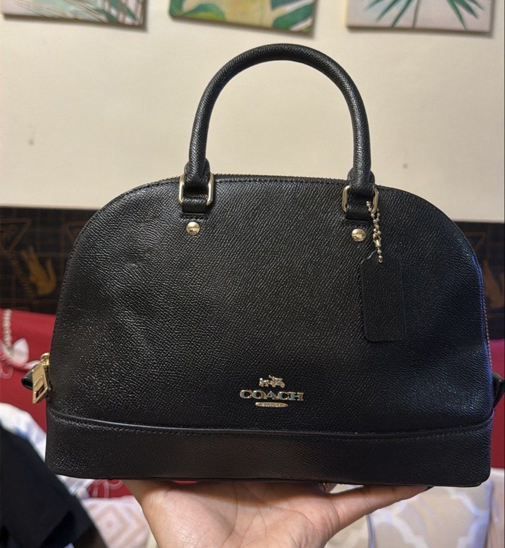 Coach Black Leather Satchel Handbag (Category: Luxury Bags & Wallets) located in Manila. Submitted by iamrfe (Listing ID 1469871115, Image 1). Description: - Brand: Coach - Style: Black leather dome satchel - Hardware: Gold-tone with metal front lettering logo - Handles: Double top handles with metal rings - Accessories: Includes leather hangtag on a beaded chain - Closure: Zip-around top closure - Base: Structured bottom panel - Material: Clean 
