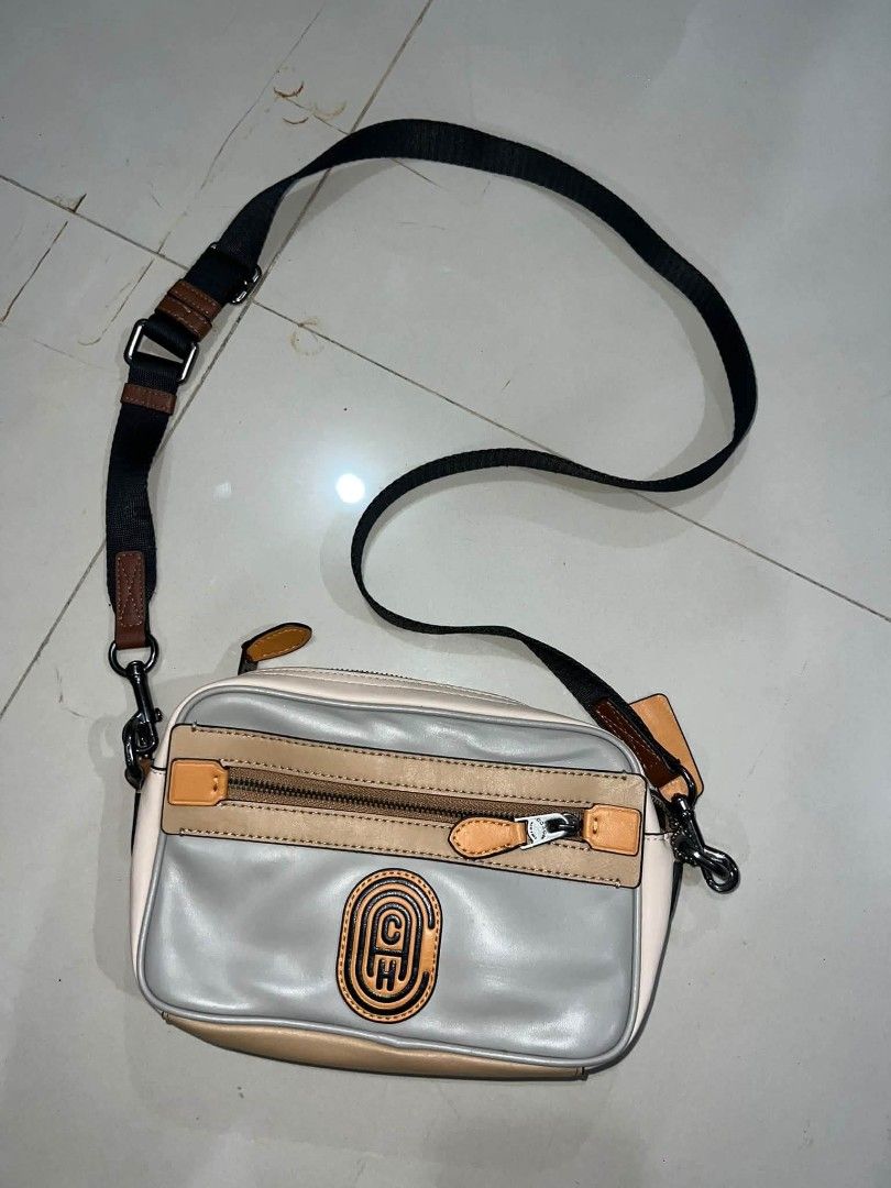 Coach Colorblock Leather Crossbody Bag (Category: Cross-body Bags) located in Manila. Submitted by zackthrift16 (Listing ID 1469868521, Image 1). Description: - Authentic Coach crossbody bag - Colorway: Stylish mix of grey, tan, and cream leather - Storage: Front zippered pocket with Coach logo patch, plus a convenient back slip pocket - Strap: Adjustable black and brown webbing strap with dark metal hardware - Extras: Includes signature leather 