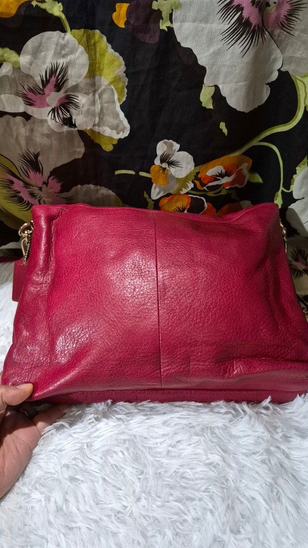 Coach Pink Leather Shoulder Bag (Category: Luxury Bags & Wallets) located in Baguio. Submitted by jhaz_bags (Listing ID 1469902493, Image 2). Description: - Brand: Coach - Material: Bright pink pebbled leather with gold-tone hardware - Closure: Secure turnlock closure - Interior: Brown satin lining with a zippered pocket and stamped serial number creed patch - Strap: Detachable chain and leather shoulder strap - Condition: Slight wear around the 