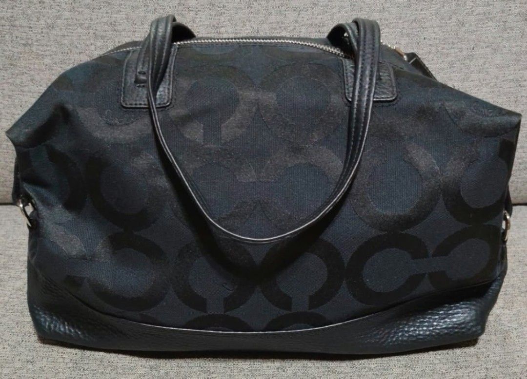 Coach Signature Black Monogram Tote Bag (Category: Luxury Bags & Wallets) located in Caloocan City. Submitted by tweetyferrer (Listing ID 1469794725, Image 2). Description: - Brand: Coach - Material: Black monogram canvas with leather trim and bottom panels - Hardware & Accents: Dual top handles and signature hanging logo charm - Closure: Top zipper closure - Interior: Spacious design featuring smooth lavender satin lining and handy slip pockets 