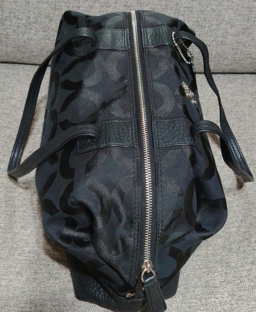 Coach Signature Black Monogram Tote Bag (Category: Luxury Bags & Wallets) located in Caloocan City. Submitted by tweetyferrer (Listing ID 1469794725, Image 3). Description: - Brand: Coach - Material: Black monogram canvas with leather trim and bottom panels - Hardware & Accents: Dual top handles and signature hanging logo charm - Closure: Top zipper closure - Interior: Spacious design featuring smooth lavender satin lining and handy slip pockets 