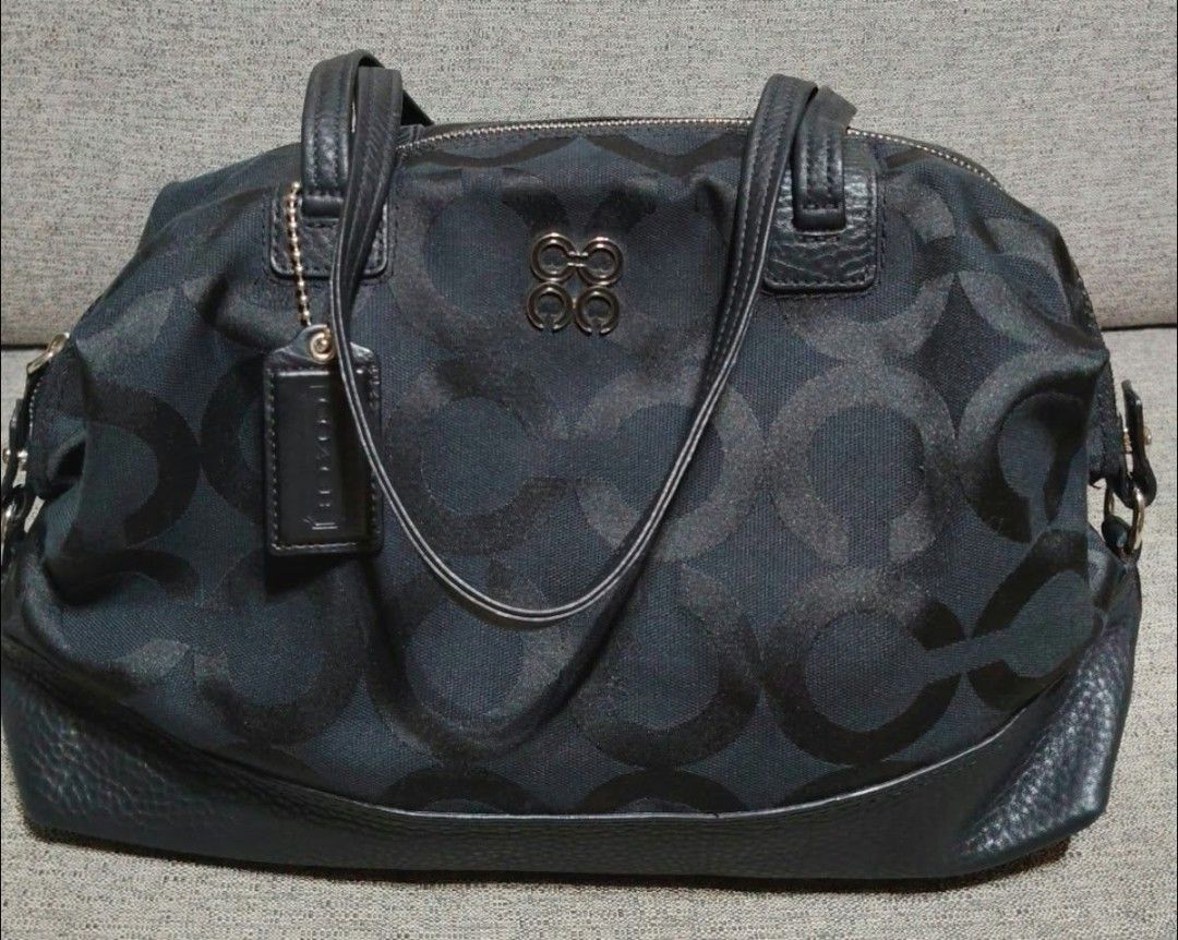 Coach Signature Black Monogram Tote Bag (Category: Luxury Bags & Wallets) located in Caloocan City. Submitted by tweetyferrer (Listing ID 1469794725, Image 1). Description: - Brand: Coach - Material: Black monogram canvas with leather trim and bottom panels - Hardware & Accents: Dual top handles and signature hanging logo charm - Closure: Top zipper closure - Interior: Spacious design featuring smooth lavender satin lining and handy slip pockets 