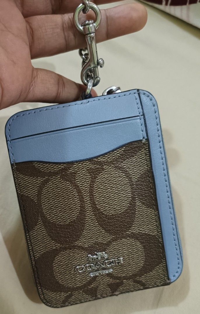 Coach Signature Canvas Card Case Wallet Light Blue (Category: Luxury Bags & Wallets) located in Capas. Submitted by rayapretty55453 (Listing ID 1469909151, Image 2). Description: - 100% Authentic Coach card case wallet - Signature monogram canvas with stylish light blue leather trim - Secure top zip compartment with polished silver hardware - Convenient chain strap with dog leash clasp - Clear ID window on the back for easy access - Multiple card