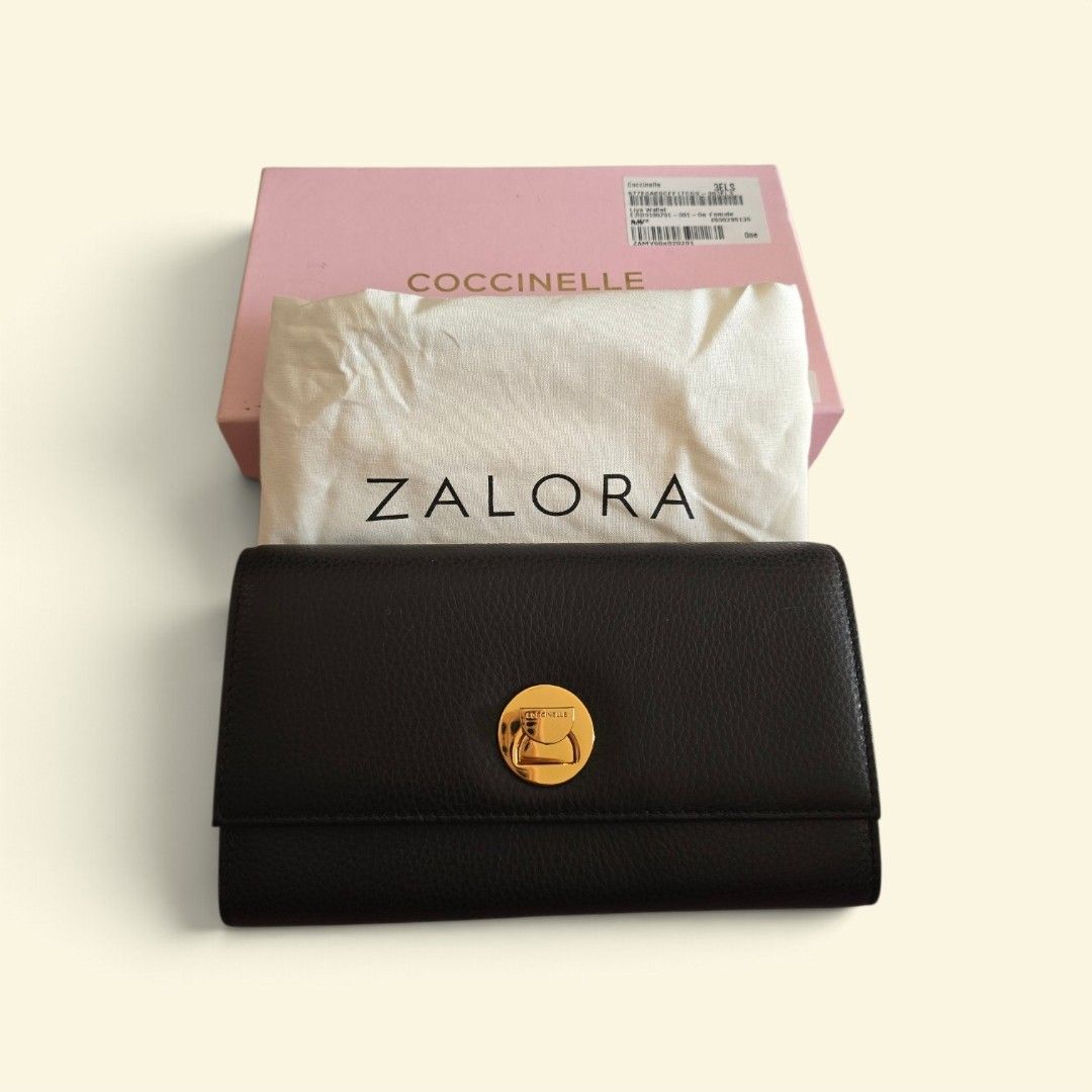 Coccinelle Liya Wallet Black (Category: Wallets & Card holders) located in Taguig. Submitted by altainfante (Listing ID 1469766335, Image 2). Description: - Brand: Coccinelle Liya Wallet - Material: Premium black pebble leather with elegant gold-tone hardware - Closure: Secure flap with signature circular twist lock - Interior: Multiple card slots, slip compartments, and a zippered coin pocket - Versatility: Comes with both a removable chain stra