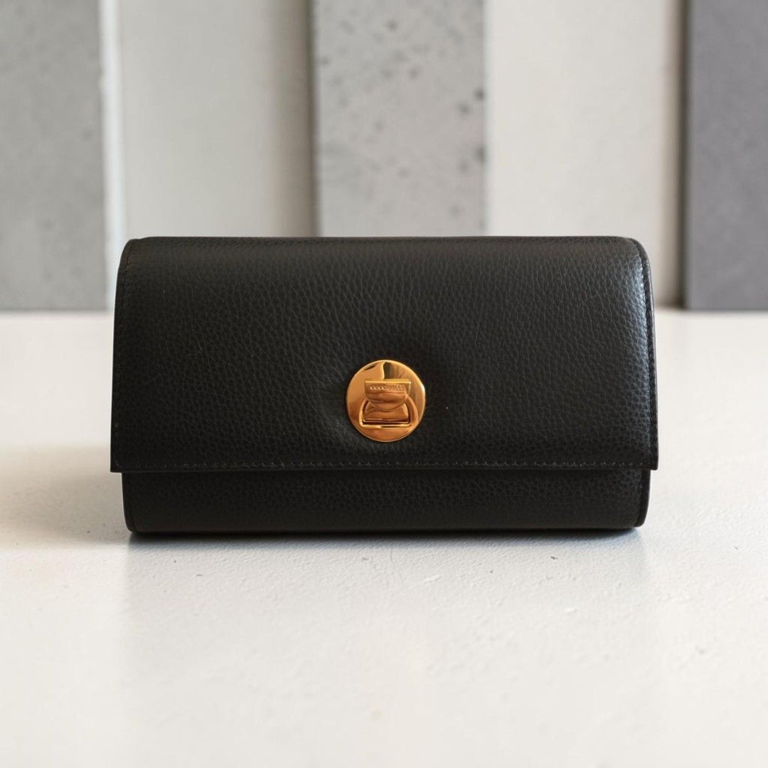 Coccinelle Liya Wallet Black (Category: Wallets & Card holders) located in Taguig. Submitted by altainfante (Listing ID 1469766335, Image 1). Description: - Brand: Coccinelle Liya Wallet - Material: Premium black pebble leather with elegant gold-tone hardware - Closure: Secure flap with signature circular twist lock - Interior: Multiple card slots, slip compartments, and a zippered coin pocket - Versatility: Comes with both a removable chain stra