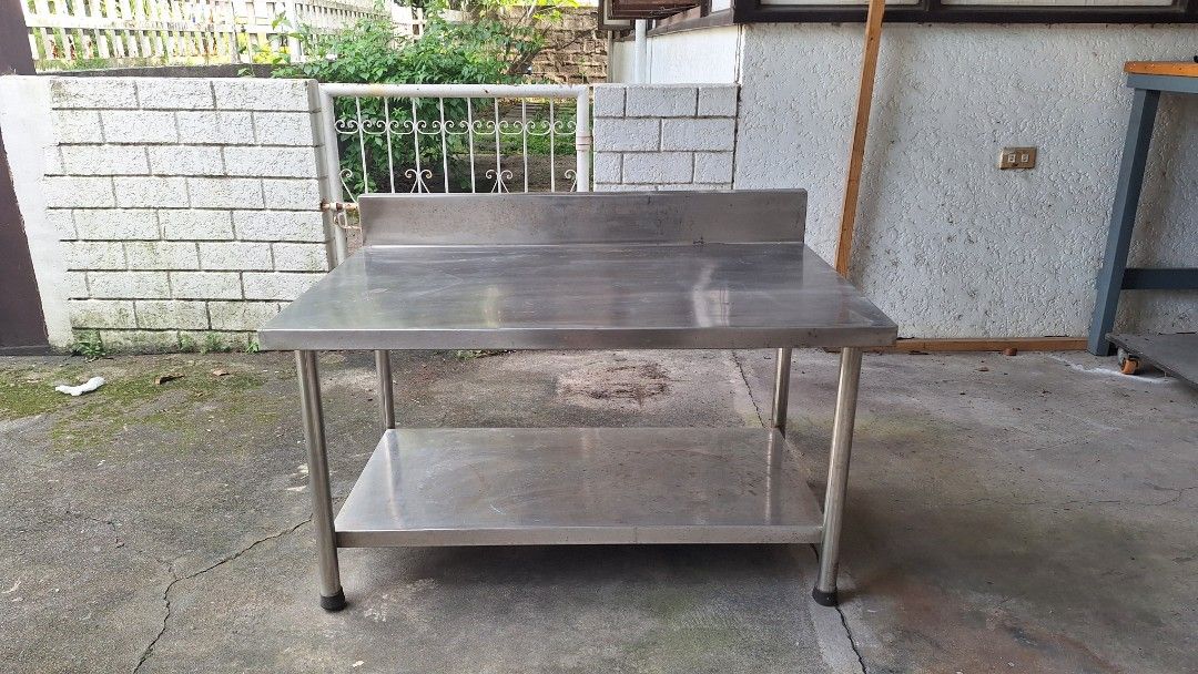Commercial Stainless Steel Kitchen Prep Table with UnderShelf (Category: Tables & Sets) located in Angeles City. Submitted by pamdiel003 (Listing ID 1469910980, Image 1). Description: - commercial grade stainless steel prep table - Includes lower storage shelf for kitchen gear and tools - Attached backsplash protects walls from splashes and messes - Sturdy round metal legs featuring adjustable feet for stability - Minor surface scratches from pre