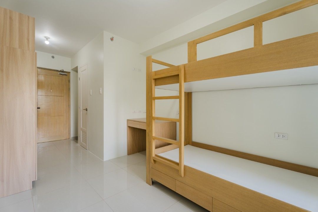Condo Unit with Pool View and Bunk Bed (Category: Shelves, Cabinets & Racks) located in Manila. Submitted by kimlacanilao02 (Listing ID 1469892099, Image 3). Description: Clean condo unit available. Includes a wooden bunk bed and a small study desk. Kitchen has a sink and cabinets. Bathroom features a toilet and shower setup. Window aircon installed. Resort-like swimming pool right outside..