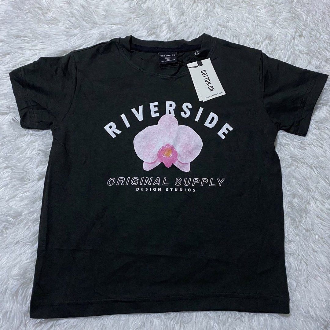 Cotton On Black Riverside Graphic Tee (Category: Shirts) located in Batangas. Submitted by strwsherry (Listing ID 1469858234, Image 1). Description: - Brand: Cotton On - Condition: Brand new with original store tag attached - Color: Black - Design: Chest graphic print with 'Riverside Original Supply Design Studios' and a pink flower - Neckline: Crew neck - Material: Soft, comfortable cotton for daily wear.