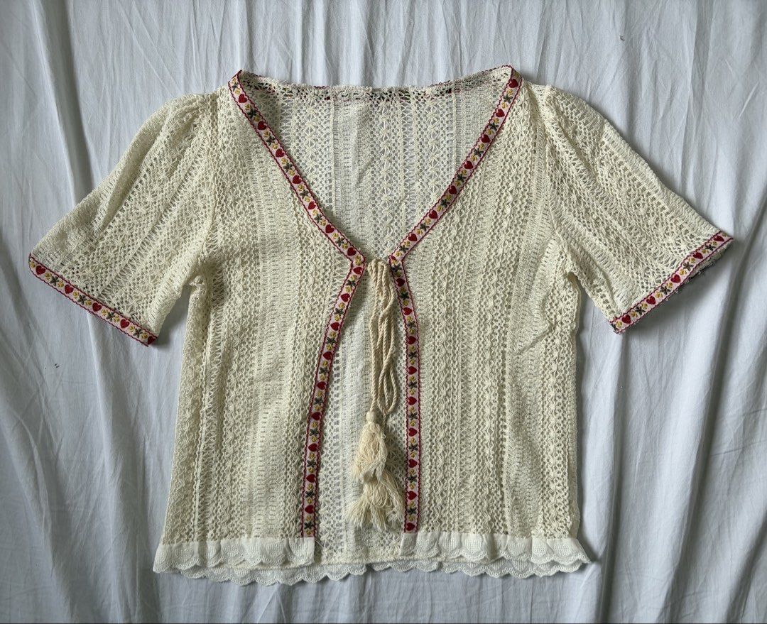 Cream Crochet Cover up Cardigan with String (Category: Coats, Jackets and Outerwear) located in Quezon City. Submitted by vidadmarie (Listing ID 1469819025, Image 1). Description: - Color/Style: Cream crochet knit cardigan with short sleeves and open front - Details: Red and yellow floral ribbon trim along the neckline, placket, and cuffs - Closure: Chest tie with playful tassel accents - Hem: Delicate scalloped eyelet lace border - Never worn - 