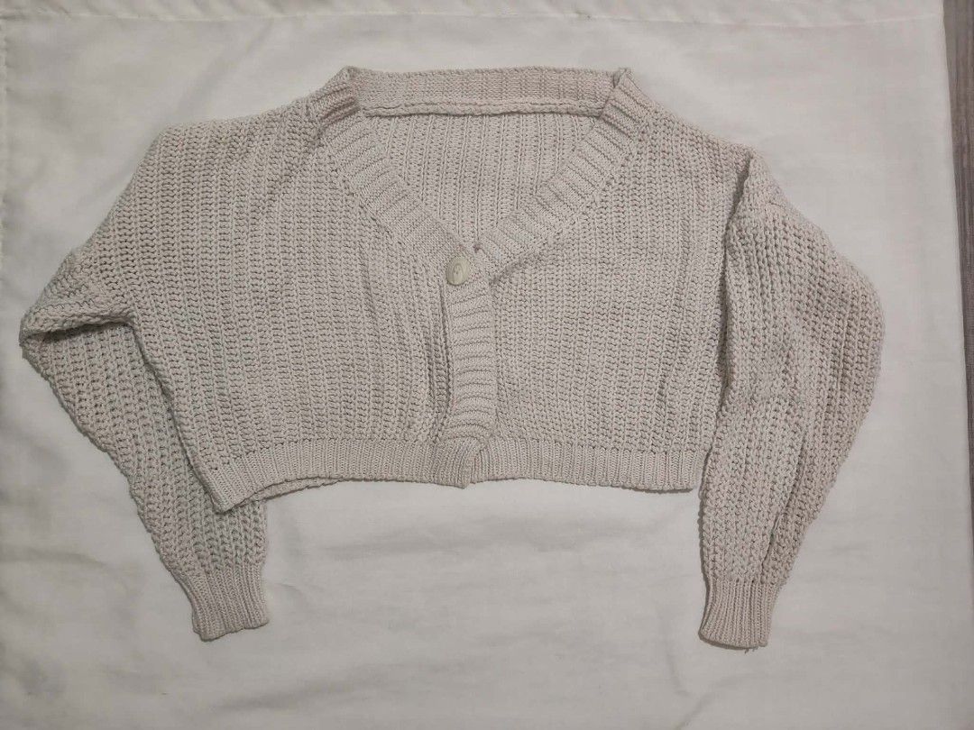Cream Cropped Knit Cardigan (Category: Coats, Jackets and Outerwear) located in Santa Rosa. Submitted by barbshie (Listing ID 1469823274, Image 1). Description: - Color: Creamy beige - Fit: Cropped with long balloon sleeves - Design: Single button closure at neckline, V-neck, and ribbed cuffs - Texture: Chunky textured yarn throughout - Styling: Great for easy layering over tees or dresses.