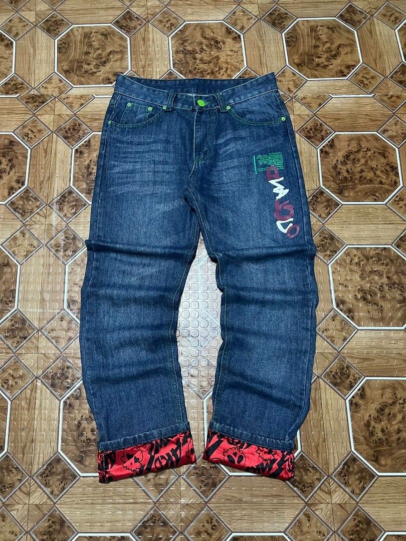 Custom Printed Denim Jeans with Red Cuffs (Category: Jeans) located in Cagayan de Oro. Submitted by friderickv99131 (Listing ID 1469920608, Image 1). Description: Dark wash denim jeans, straight fit. Custom graffiti art printed on one back pocket and front leg. Red satin cuffs with skull prints rolled at the bottom. Green contrast stitching and neon green button accents. Back pocket includes a Stone Island style compass patch..