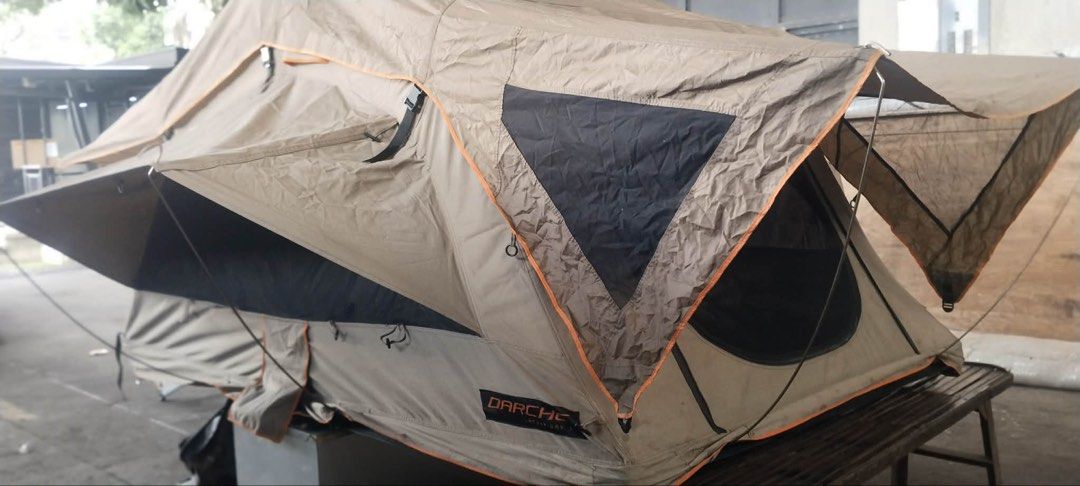 Darche rooftop tent (Category: Hiking & Camping) located in Marikina City. Submitted by studiogammo (Listing ID 1469861638, Image 1). Description: Darche intrepidor 2 RTT - Material: Heavy-duty khaki/brown canvas with orange trim and black contrast panels - Comfort: Built-in mattress and internal storage pockets - Hardware: Includes support poles and sturdy frame - Condition: LIGHTLY USED Ready for overlanding, road trips, and outdoor camping.