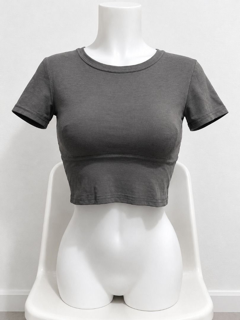 Dark Grey Short Sleeve Crop Top (Category: Shirts) located in San Jose. Submitted by lerwomensthrift (Listing ID 1469907858, Image 2). Description: - Color: Solid dark grey - Fit: Fitted style crop top - Details: Short sleeves, rounded neckline - Styling: Perfect for pairing with high-waisted denim or skirts.