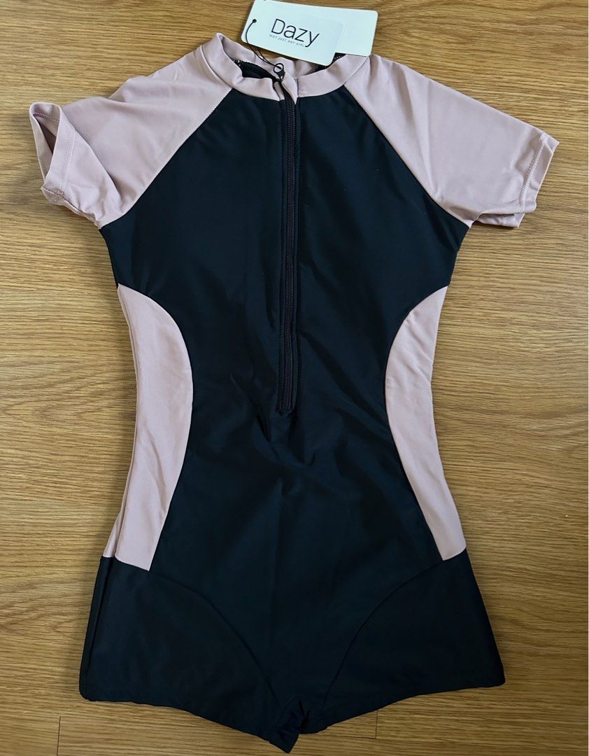 Dazy Short Sleeve Zip Front Swimsuit Romper (Category: Bikinis & Swimsuits) located in Mandaluyong City. Submitted by unworntobarelyworn (Listing ID 1469858415, Image 2). Description: - Brand: Dazy - Condition: Brand new with tags, never worn - Size: S - Design: Black and pink contrast with solid color-blocking along the sides - Features: Front zipper closure, short sleeves, and built-in shorts style.