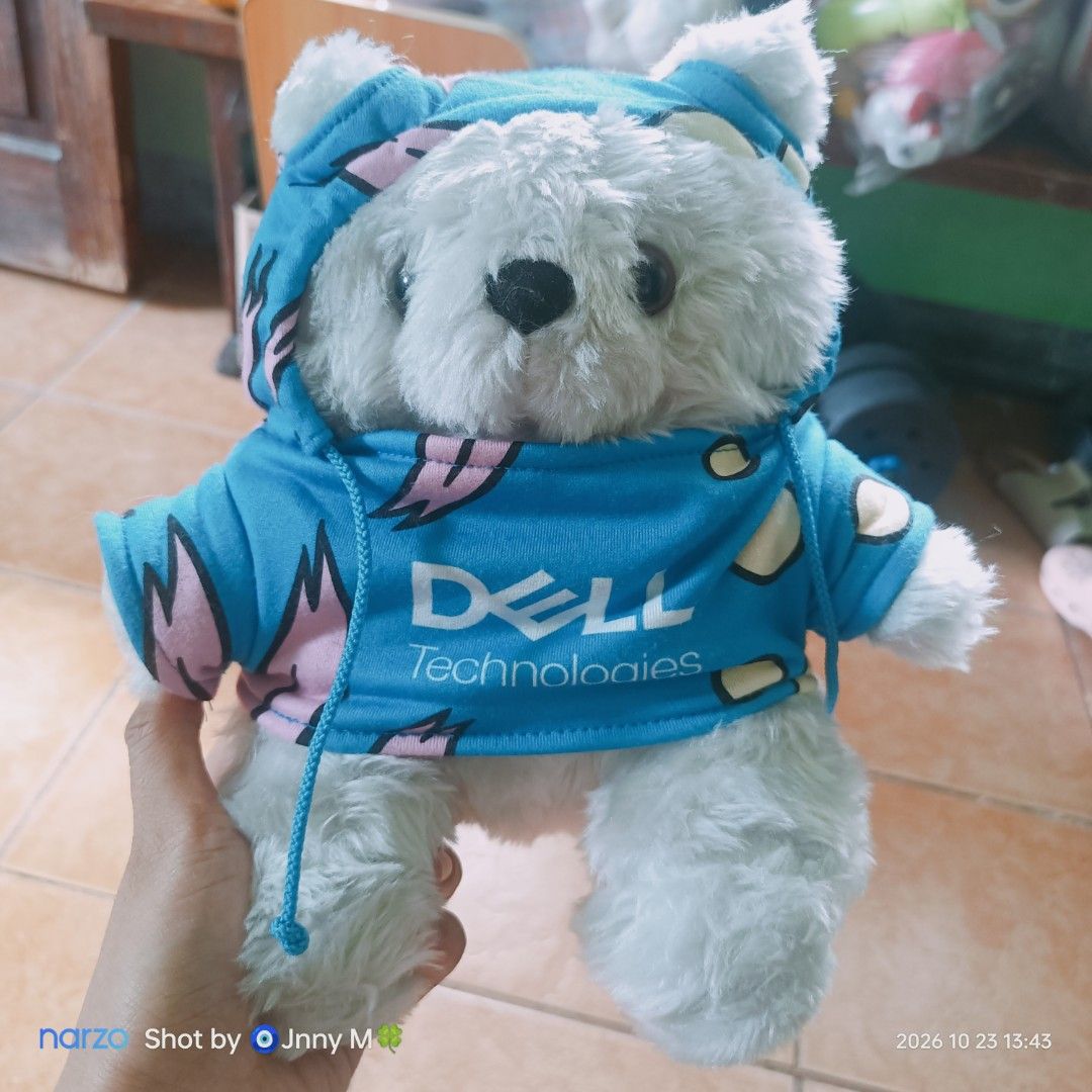 Dell Technologies Branded White Teddy Bear Plush Toy (Category: Plushies & Soft Toys) located in Taguig. Submitted by mhayestufftoys (Listing ID 1469837747, Image 1). Description: - Color: White bear with blue hoodie - Branding: Official Dell Technologies logo on the front - Material: Ultra-soft plush fabric - Features: Attached hood with functional drawstrings and playful graphic pattern - Condition: Clean, fluffy, and well-maintained.