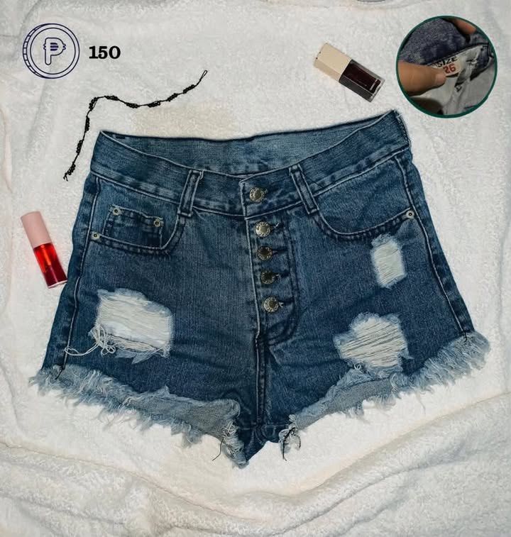 Denim Shorts (Category: Shorts) located in Cebu City. Submitted by venomouswhisk (Listing ID 1469817112, Image 1). Description: - Style: High-waisted denim shorts with a multi-button front closure - Details: Distressed patches on both legs and trendy raw frayed hems - Pockets: Classic five-pocket style for everyday convenience - Size: Tagged Size 26 - Condition: Brand new with tags (BNWT), excellent quality - Mode of Payment: GCash, - Shipping: S