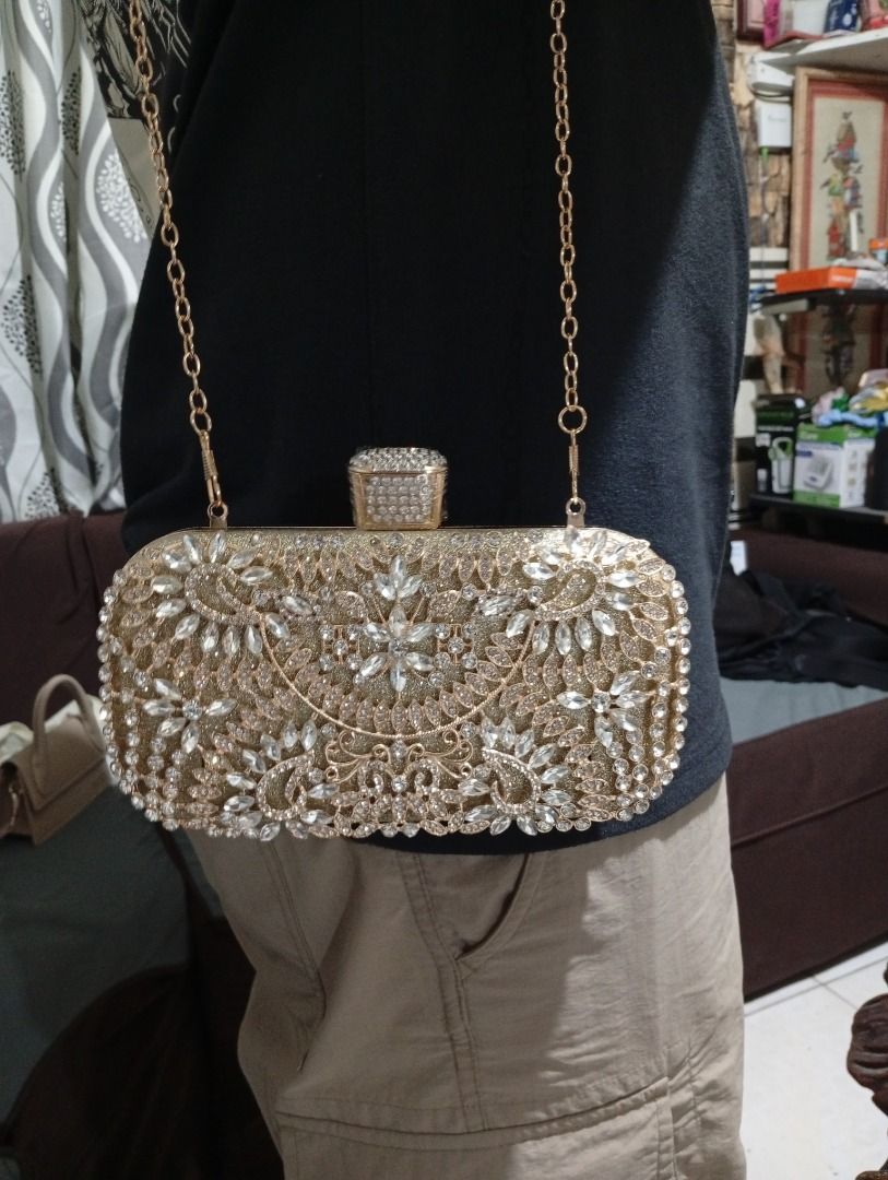 Diamond Evening Clutch Bag – Golden (Category: Clutches) located in Bulacan. Submitted by camsaey (Listing ID 1469799780, Image 1). Description: - Condition: Brand new - Design: Hard case covered in sparkling rhinestones and crystals with a decorative crystal clasp - Interior: Faux leather lining - Strap: Includes a matching gold chain for shoulder or crossbody wear - Perfect for: Weddings, parties, proms, and formal events - Color: Gold comes wi