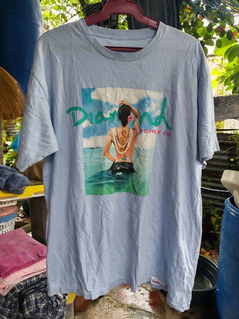 Diamond Supply Co. Graphic T-Shirt Light Blue (Category: Tshirts & Polo Shirts ) located in Sipalay. Submitted by boldowl.e4f283 (Listing ID 1469809190, Image 1). Description: - Brand: Diamond Supply Co. - Color: Light Blue - Size: Large - Design: Large graphic print of person with tiger tattoo, accented with teal and red logo lettering - Fit: Relaxed fit with classic crewneck - Details: Signature Diamond logo tag near bottom hem - Material: Soft