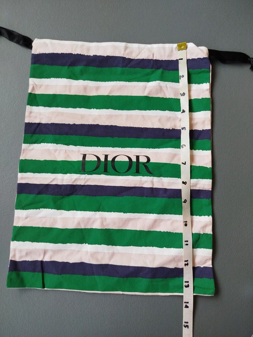 Dior Striped Dust Bag Pouch Drawstring (Category: Luxury Bags & Wallets) located in Calamba. Submitted by merrymerida (Listing ID 1469762075, Image 2). Description: - 100% Authentic Dior dust bag - Features a stylish green, pink, navy blue, and white stripe pattern - Large black Dior logo printed prominently on the center front - Secure black drawstring closure at the top - Dimensions: approx. 11" wide x 13.5" long - Clean fabric throughout with 
