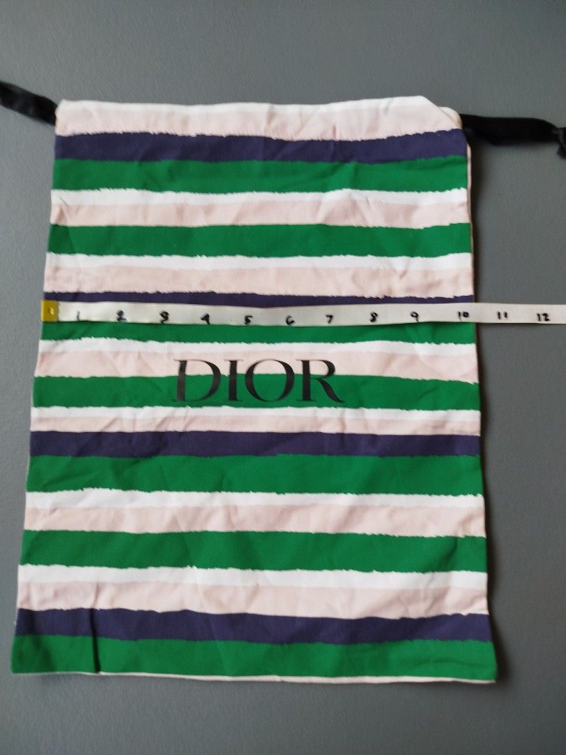 Dior Striped Dust Bag Pouch Drawstring (Category: Luxury Bags & Wallets) located in Calamba. Submitted by merrymerida (Listing ID 1469762075, Image 1). Description: - 100% Authentic Dior dust bag - Features a stylish green, pink, navy blue, and white stripe pattern - Large black Dior logo printed prominently on the center front - Secure black drawstring closure at the top - Dimensions: approx. 11" wide x 13.5" long - Clean fabric throughout with 