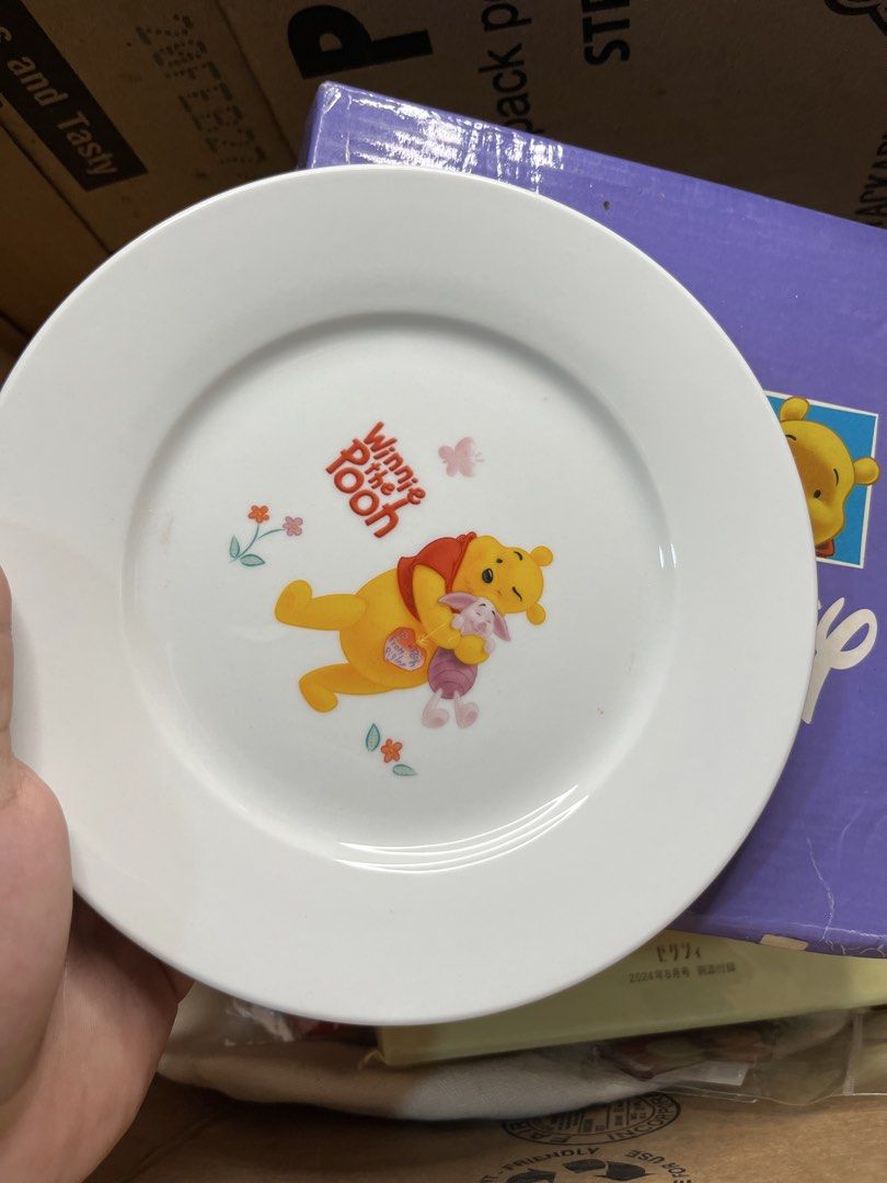 Disney Winnie the Pooh ceramic plate with box (Category: Dinnerware & Cutlery) located in Gapan. Submitted by lunashop14 (Listing ID 1469824496, Image 2). Description: - Official Disney merchandise: Winnie the Pooh & Piglet ceramic plate by Way Link - Design: Features Pooh and Piglet with lovely floral accents and butterflies - Size: Standard dessert/snack plate size - Packaging: Includes original purple Disney branded storage box - Condition: Br