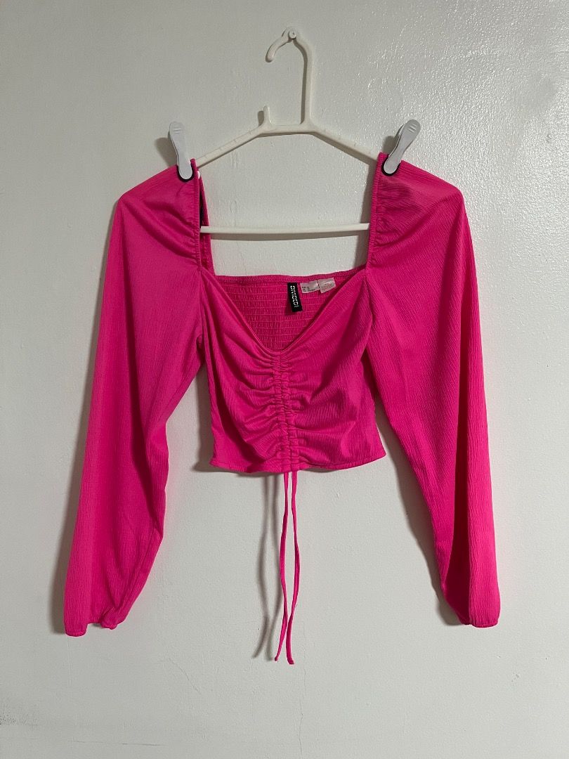 Divided by H&M Hot Pink Crop Top (Category: Shirts) located in Cabuyao City. Submitted by rdtrmt (Listing ID 1469875577, Image 1). Description: - Brand: Divided by H&M - Size: XS - Color: Bright hot pink - Details: Square neckline, long sleeves, smocked bodice, and center front ruching with adjustable drawstring ties - Fabric: Textured crinkle material - Condition: Worn once, still in good condition.