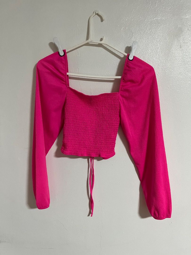 Divided by H&M Hot Pink Crop Top (Category: Shirts) located in Cabuyao City. Submitted by rdtrmt (Listing ID 1469875577, Image 2). Description: - Brand: Divided by H&M - Size: XS - Color: Bright hot pink - Details: Square neckline, long sleeves, smocked bodice, and center front ruching with adjustable drawstring ties - Fabric: Textured crinkle material - Condition: Worn once, still in good condition.