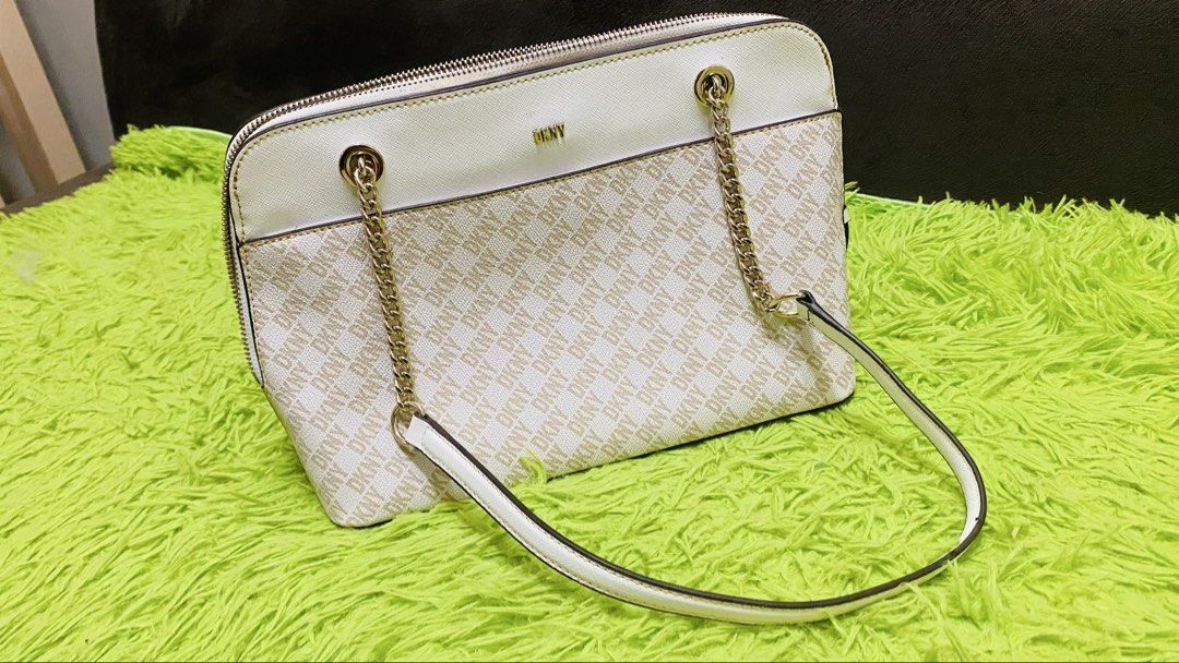 DKNY shoulder/satchel bag (Category: Shoulder Bags) located in Bulacan. Submitted by majo0425 (Listing ID 1469792467, Image 1). Description: white and beige monogram-patterned DKNY shoulder/satchel bag featuring gold-tone chain handles and a detachable crossbody strap..