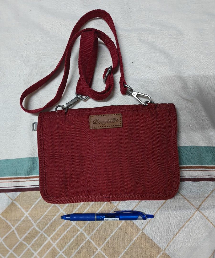 Doughnut Red Crossbody Shoulder Bag (Category: Cross-body Bags) located in Pasig City. Submitted by she_declutters_ph (Listing ID 1469917146, Image 2). Description: - Brand: Doughnut - Size: 8.5 x 6 inches Compact and lightweight, ideal for carrying your daily essentials Used this as an airport bag. - Color: Vibrant Red - Material: Durable canvas with stylish silver metal hardware - Closure: Secure snap-button flap and zippered main compartment -
