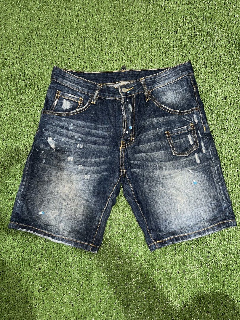 DSQUARED2 Distressed Denim Shorts Paint Splatter (Category: Shorts) located in Manila. Submitted by nevahhbrokeagain (Listing ID 1469890899, Image 1). Description: - Brand: DSQUARED2 - Item: Distressed Denim Shorts - Wash: Dark blue with unique white and blue paint splatter details - Features: Distressed patches, contrasting yellow stitching, button fly with branded tab, rear pocket embroidery, and DSQUARED logo text on back pocket - Material: He