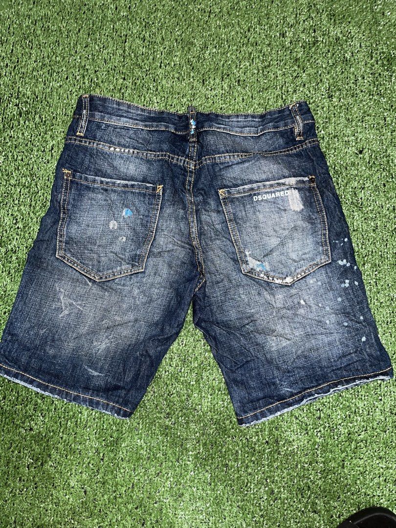 DSQUARED2 Distressed Denim Shorts Paint Splatter (Category: Shorts) located in Manila. Submitted by nevahhbrokeagain (Listing ID 1469890899, Image 2). Description: - Brand: DSQUARED2 - Item: Distressed Denim Shorts - Wash: Dark blue with unique white and blue paint splatter details - Features: Distressed patches, contrasting yellow stitching, button fly with branded tab, rear pocket embroidery, and DSQUARED logo text on back pocket - Material: He