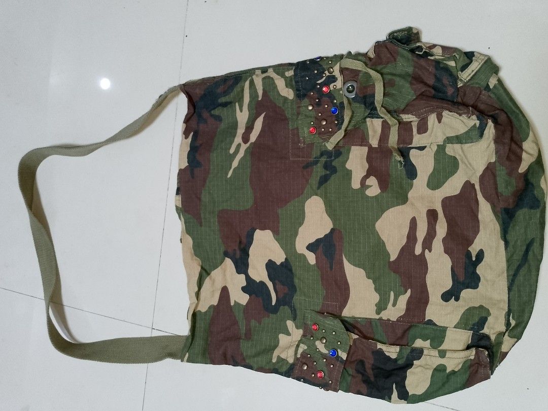 Ed Hardy Camo Shoulder Bag with Patches and Studs (Category: Shoulder Bags) located in Manila. Submitted by mjthrifted_second (Listing ID 1469820530, Image 2). Description: Green camouflage canvas shoulder bag by Ed Hardy. Multiple front pockets with button flaps, metal studs, and colorful rhinestone accents. Embroidered tiger patches and Ed Hardy script logo on the front. Adjustable strap and fabric lining inside. Casual everyday carryall with p