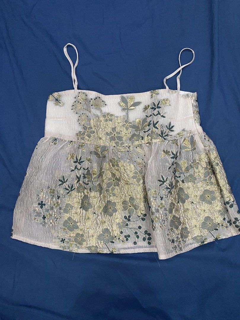 EMo Floral Metallic Camisole Top Size S (Category: Sleeveless) located in Manila. Submitted by escherichiaa (Listing ID 1469803208, Image 1). Description: - Brand: EMo - Size: S - Color/Design: Light pink base with metallic gold floral embroidery and dark green botanical patterns - Neckline & Straps: Square neckline with thin adjustable spaghetti straps - Fit: Empire waistline with a flowy, flared silhouette - Details: Side zipper closure and sof