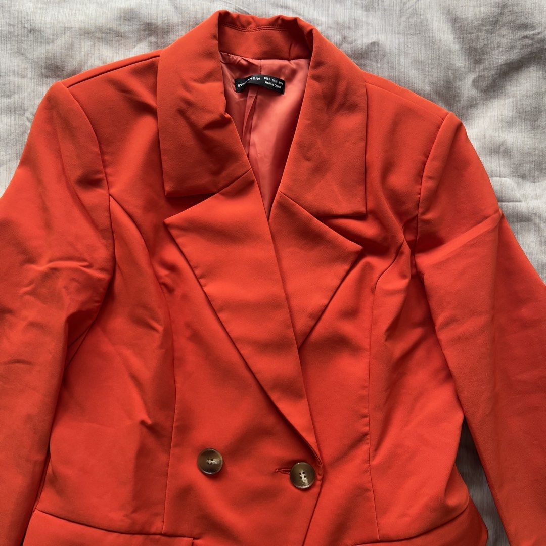 Evolushein Orange Double-Breasted Blazer Size S (Category: Coats, Jackets and Outerwear) located in Pasig City. Submitted by jenscloset86 (Listing ID 1469803401, Image 2). Description: Brand: SHEIN (Evolushein) Size: SMALL Color: Bright Orange/ Red Orange • BRAND NEW (but washed once). • Never used, never worn. • No flaws, no damages. Measurement: Shoulder: 16” Bust: 36” Length: 29.5” Sleeve: 26”.