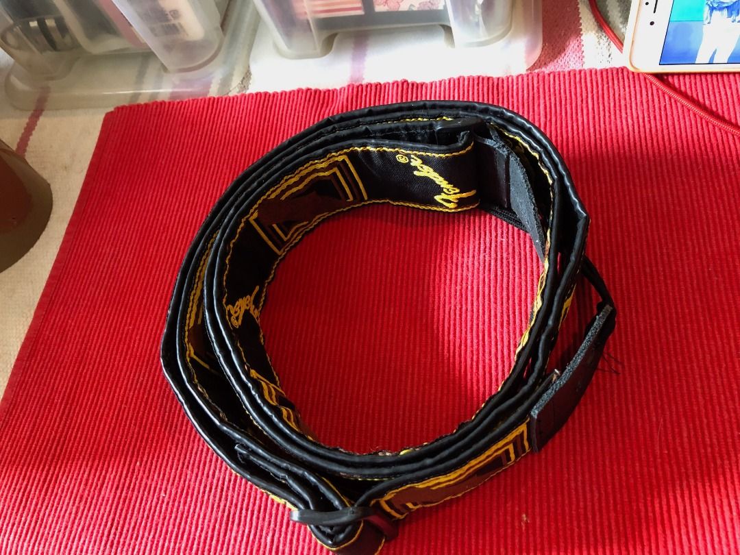 Fender Guitar Strap Black Yellow Brown (Category: Musical Instruments) located in Calamba. Submitted by marjoh29436 (Listing ID 1469856116, Image 1). Description: An Authentic Fender guitar strap / Stylish black background with embroidered logos and geometric patterns / Eye-catching yellow script and brown box details / Adjustable plastic buckle for a custom fit / Durable leather ends with standard peg holes / Clean fabric and solid stitching thr