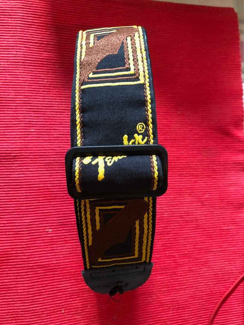 Fender Guitar Strap Black Yellow Brown (Category: Musical Instruments) located in Calamba. Submitted by marjoh29436 (Listing ID 1469856116, Image 2). Description: An Authentic Fender guitar strap / Stylish black background with embroidered logos and geometric patterns / Eye-catching yellow script and brown box details / Adjustable plastic buckle for a custom fit / Durable leather ends with standard peg holes / Clean fabric and solid stitching thr