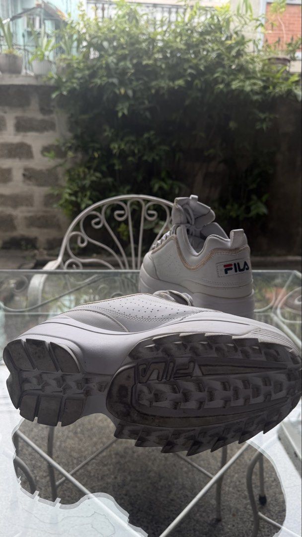 Fila Disruptor 2 Wedge White Sneakers US 9 (Category: Sneakers) located in Calamba. Submitted by rafabariso (Listing ID 1469759677, Image 3). Description: - Brand: Fila Disruptor 2 Wedge - Color: White - Size: US 9 (27.0 cm) - Style: Chunky platform with iconic branding on tongue, side, and heel pull - Inclusions: Original shoe box - Condition: Moderate wear with visible scuffs and creasing on uppers, plus dirt on rubber outsoles.