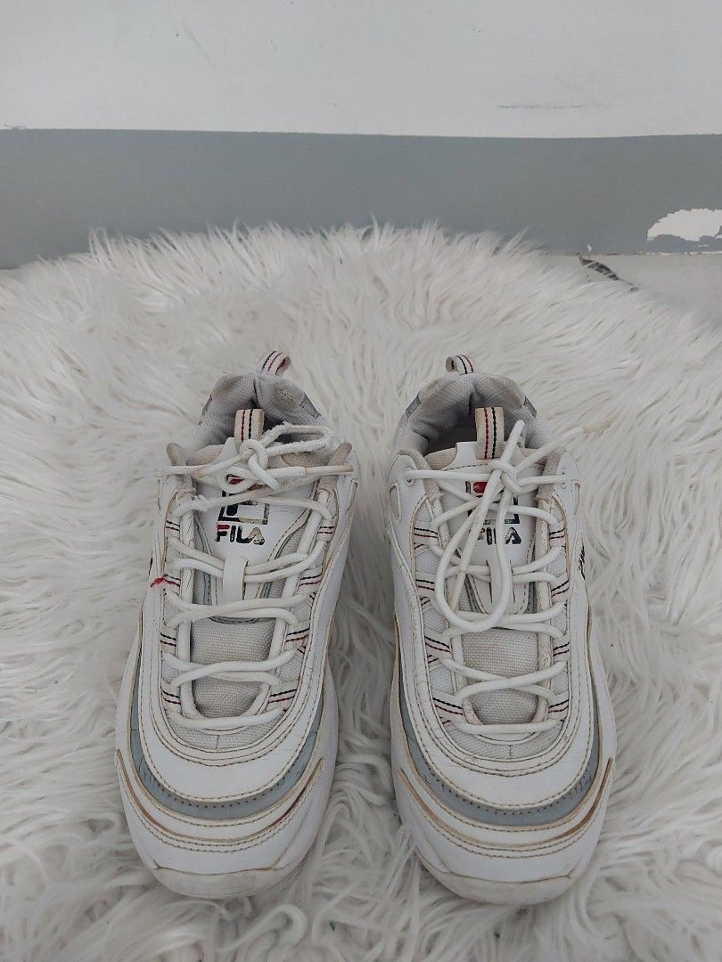 Fila White Chunky Sneakers Size US 6 (Category: Sneakers) located in Cavite. Submitted by tobias_7795 (Listing ID 1469826379, Image 1). Description: - Brand: Fila chunky sneakers - Color: White with gray trim and red-and-blue accents - Size: US 6 (MM 240) - Origin: Made in Vietnam - Features: Lace-up closure, branded tongues, and striped pull tabs at the heel - Condition: Pre-owned with light scuffs and dirt marks on soles and uppers.