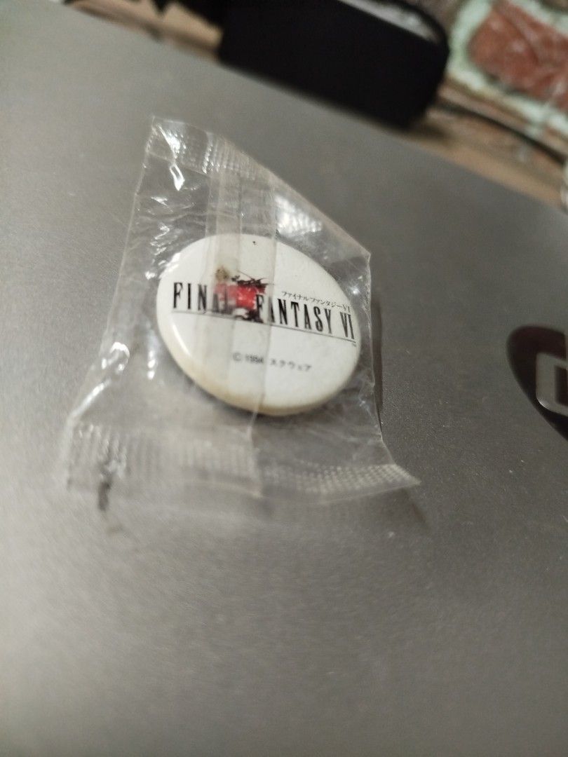 Final Fantasy VI 1994 Square Pin Badge (Category: Vintage Collectibles) located in Binan City. Submitted by pumpkiiin02 (Listing ID 1469916791, Image 3). Description: - Authentic 1994 Square Final Fantasy VI collectible pin - Features the iconic classic red logo design - Format: Small round lapel pin - A must-have rare vintage piece for JRPG fans and collectors Condition: - Slightly opened seal at the back - With visible yellow stains (at the low