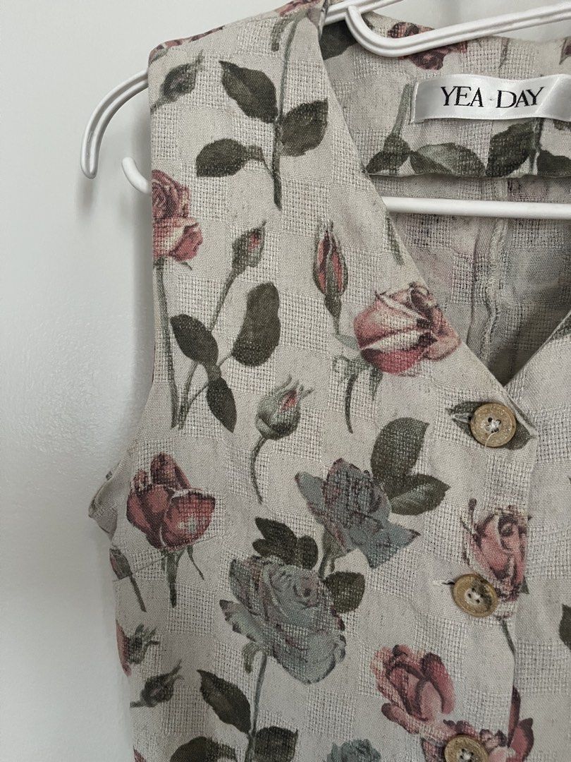 Floral Button Vest (Category: Sleeveless) located in Lapu Lapu. Submitted by alexisdeclutters (Listing ID 1469787924, Image 2). Description: - Brand: YEA DAY - Color/Design: Neutral beige with all-over pink and blue rose print with green leaves - Style: Sleeveless V-neck vest with a trendy cropped hem - Closure: 4 round wooden-style front buttons - Condition: Excellent/Brand new with tag -.