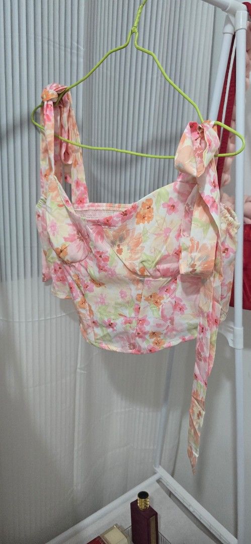 Floral Print Crop Top with Strap Ties (Category: Sleeveless) located in Manila. Submitted by cee_gotaway6991 (Listing ID 1469826207, Image 1). Description: - Vibrant pink, orange, and yellow floral all-over pattern - Adjustable built-in straps that tie at the shoulders - Lightweight, breathable fabric ideal for warm weather - Trendy cropped length, perfect for high-waisted shorts or skirts .