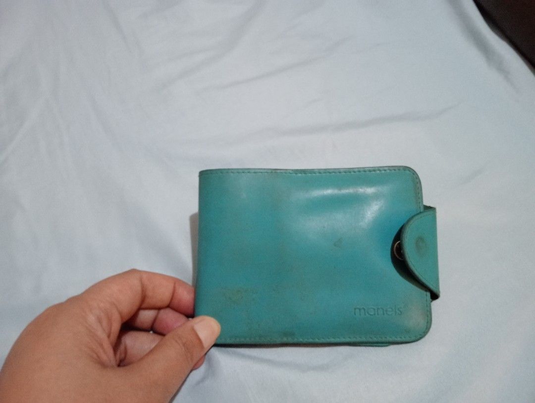Folding turquoise genuine leather folding wallet card holder (Category: Wallets & Card holders) located in Makati City. Submitted by YSL80022 (Listing ID 1469878760, Image 1). Description: - Brand: Manels - Color: Turquoise - Closure: Side snap button - Features: Multiple card slots, ID window, and bill compartment with dark fabric lining - Condition: Shows visible wear, scuffs, and discoloration on exterior and interior leather, but closure and 