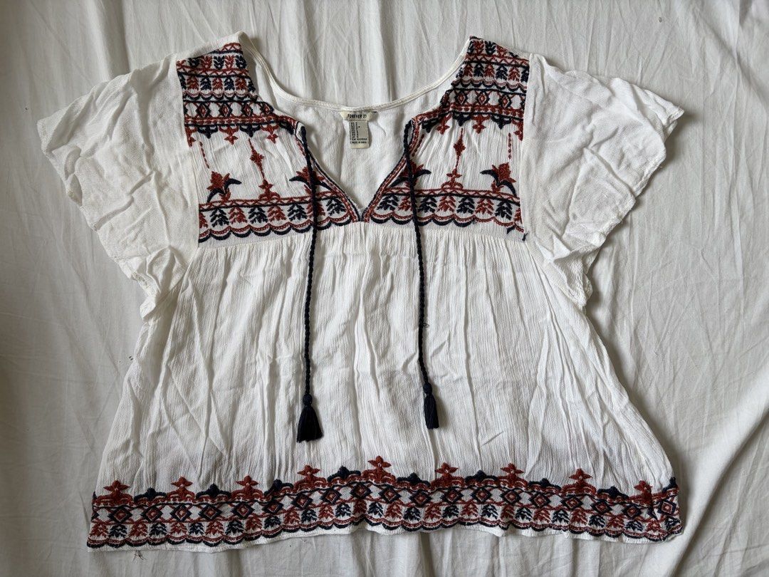 Forever 21 White Boho Embroidered Blouse (Category: Blouses) located in Quezon City. Submitted by vidadmarie (Listing ID 1469819027, Image 1). Description: - Brand/Model: Forever 21 - Size: Small (tag attached) - Details: V-neckline with tassel drawstrings and short flutter sleeves - Condition: Clean, well-maintained overall.